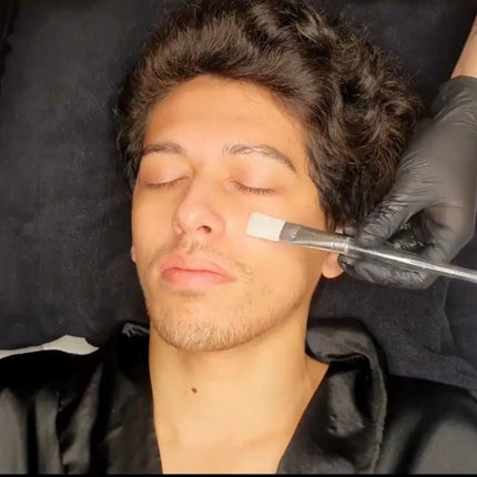 Tratamiento facial con sérum aplicado en el rostro de un hombre