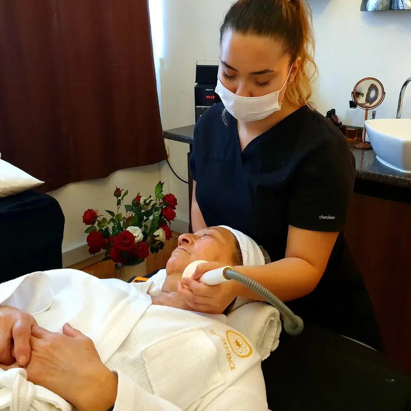 Profesional aplicando radiofrecuencia TriLipo en el rostro de una mujer